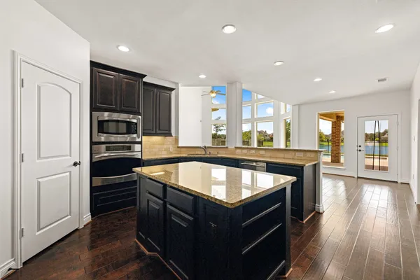 a kitchen with stainless steel appliances granite countertop a stove and a refrigerator