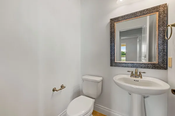 a bathroom with a toilet sink and mirror