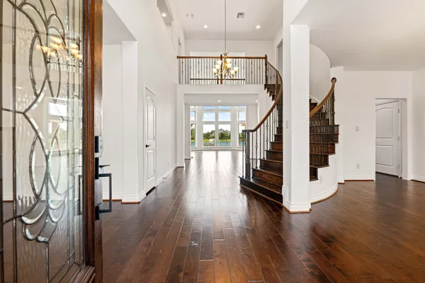 a view of a hallway with wooden floor and staircase