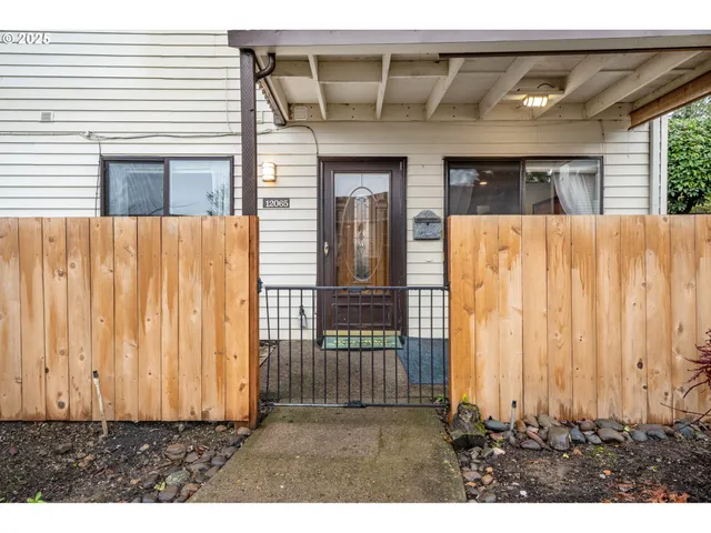 a view of a house with wooden fence