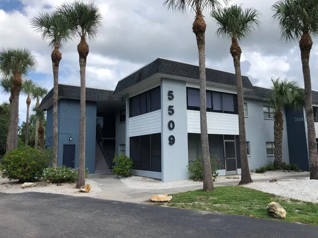 a front view of a house with yard and parking