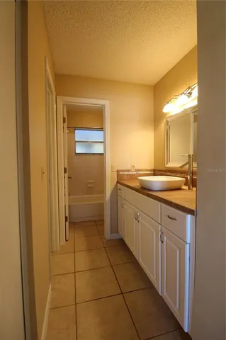 a bathroom with a granite countertop sink a mirror and a bathtub