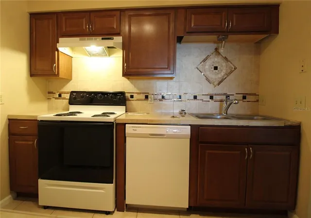 a kitchen with a sink a stove and a microwave