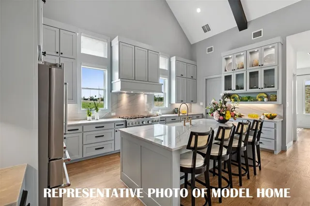 a kitchen with stainless steel appliances granite countertop a stove top oven a sink a dining table and chairs with wooden floor