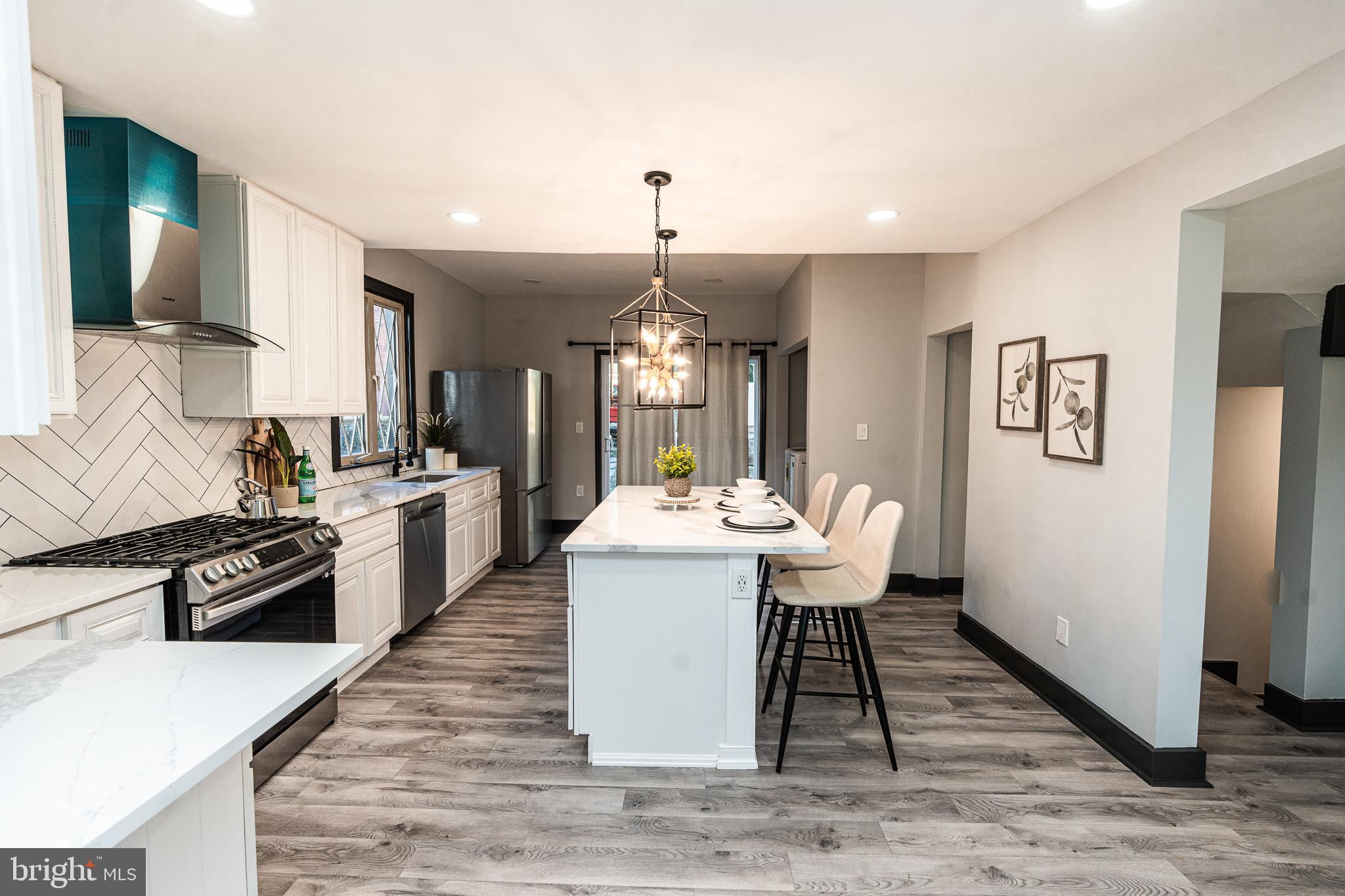 3910 Chatham Road Baltimore, MD 21207 - Photo 9 of 52 a large white kitchen with wooden floor and stainless steel appliances