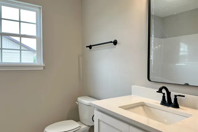 a bathroom with a sink a toilet and a mirror