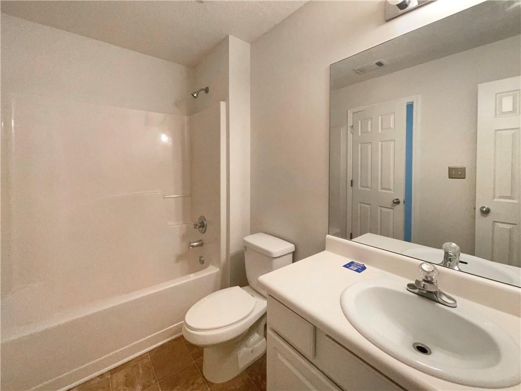 5945 Raventree Court Atlanta, GA 30349 - Photo 13 of 27 a bathroom with a sink a toilet and shower