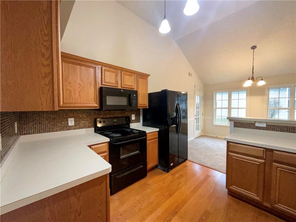 5945 Raventree Court Atlanta, GA 30349 - Photo 19 of 27 a kitchen with stainless steel appliances a stove refrigerator sink and microwave