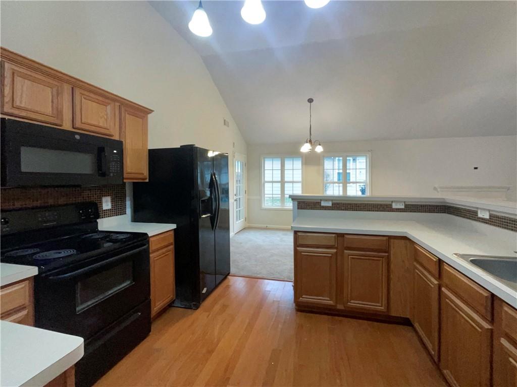 5945 Raventree Court Atlanta, GA 30349 - Photo 20 of 27 a kitchen with granite countertop stainless steel appliances and wooden cabinets