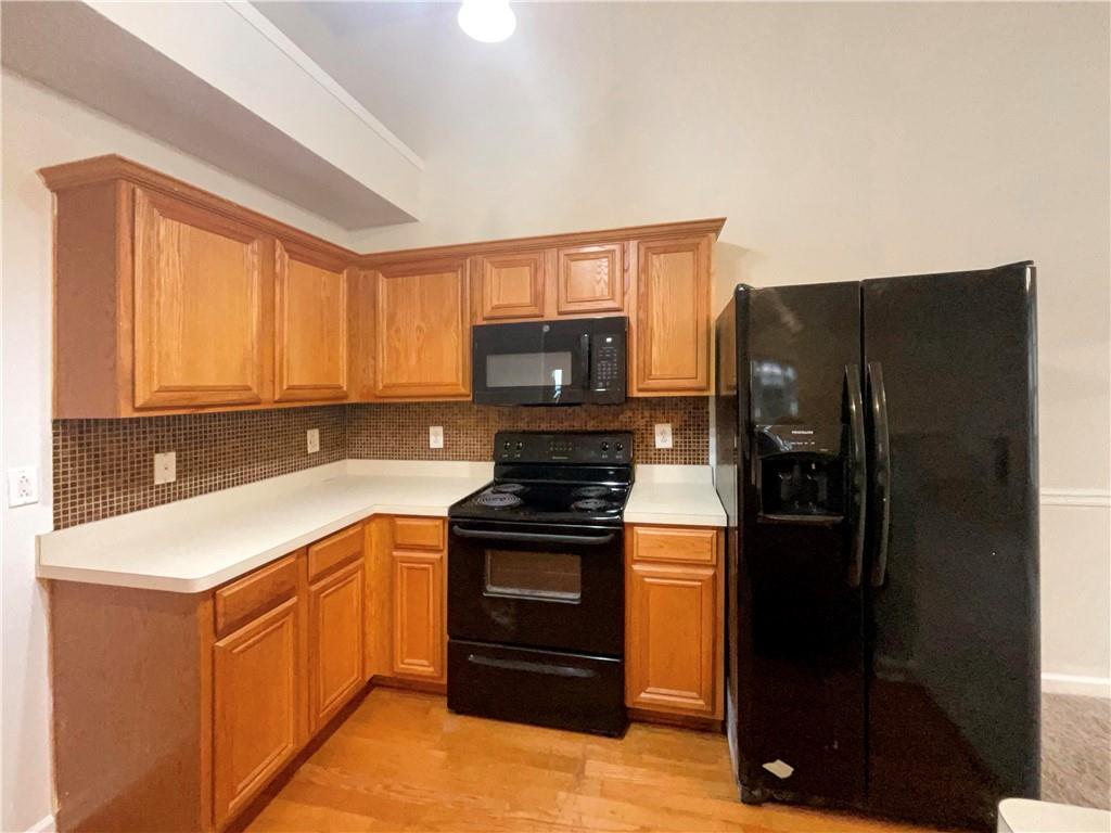 5945 Raventree Court Atlanta, GA 30349 - Photo 2 of 27 a kitchen with a refrigerator stove and microwave
