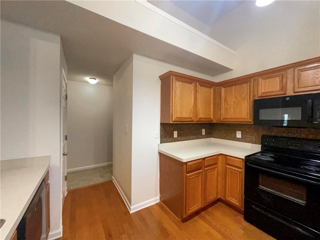 5945 Raventree Court Atlanta, GA 30349 - Photo 21 of 27 a kitchen with a sink a stove and cabinets