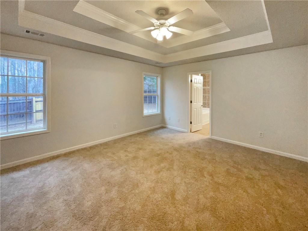 5945 Raventree Court Atlanta, GA 30349 - Photo 4 of 27 en empty room with windows and ceiling fan