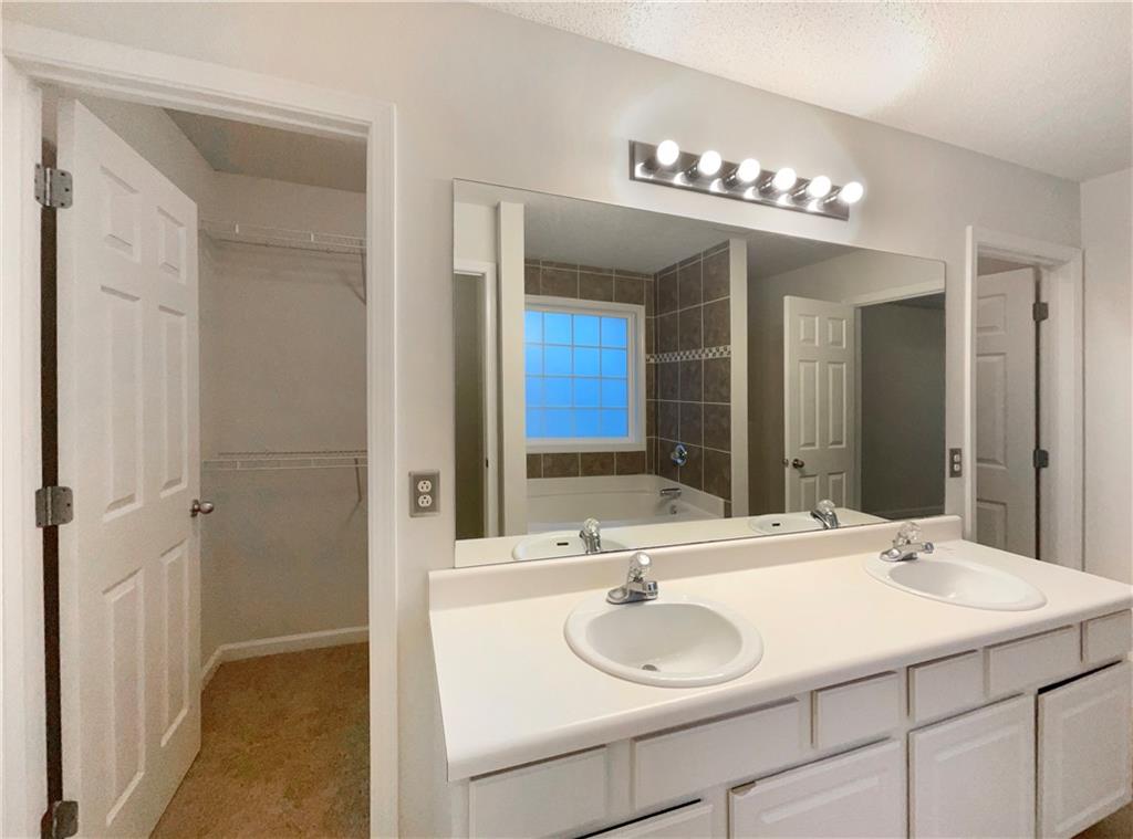 5945 Raventree Court Atlanta, GA 30349 - Photo 9 of 27 a bathroom with a sink and a mirror