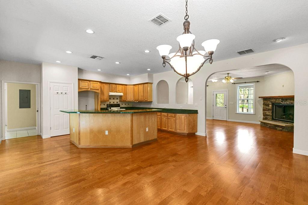 2691 Phillips Road Christmas, FL 32709 - Photo 14 of 38 a view of a living room a kitchen island wooden floor and a fireplace