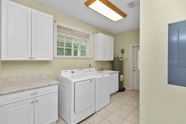 a utility room with cabinets washer and dryer