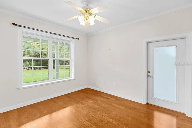 an empty room with a window and a fan