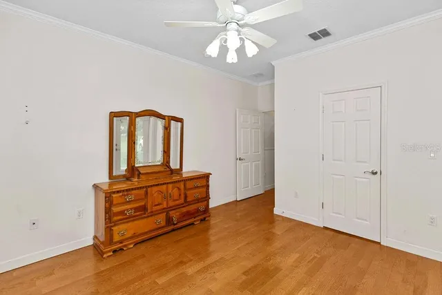 an empty room with windows and ceiling fan