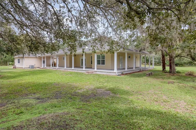 a front view of a house with a yard and trees
