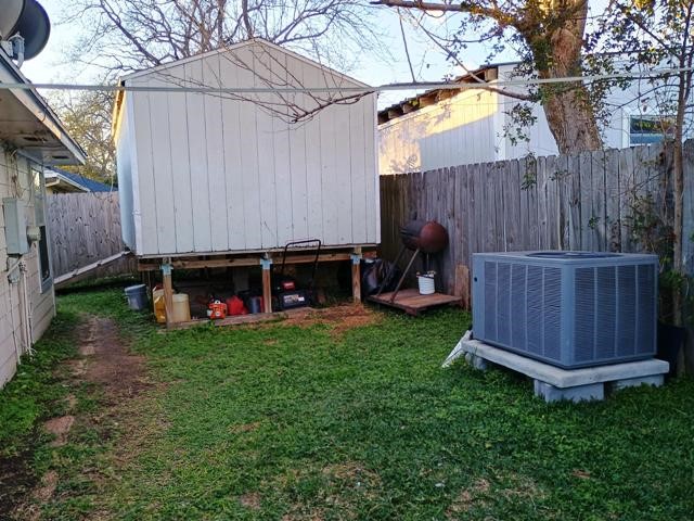 3822 Mattingham Drive Houston, TX 77066 - Photo 17 of 18 a view of a backyard with a small cabin and a chair under an umbrella