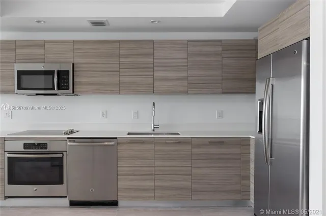 a kitchen with granite countertop cabinets stainless steel appliances and a counter space