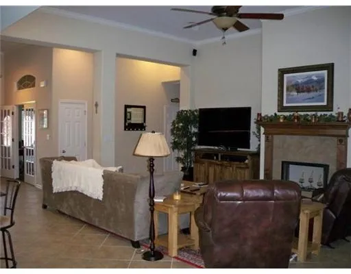 a living room with furniture a flat screen tv and a fireplace
