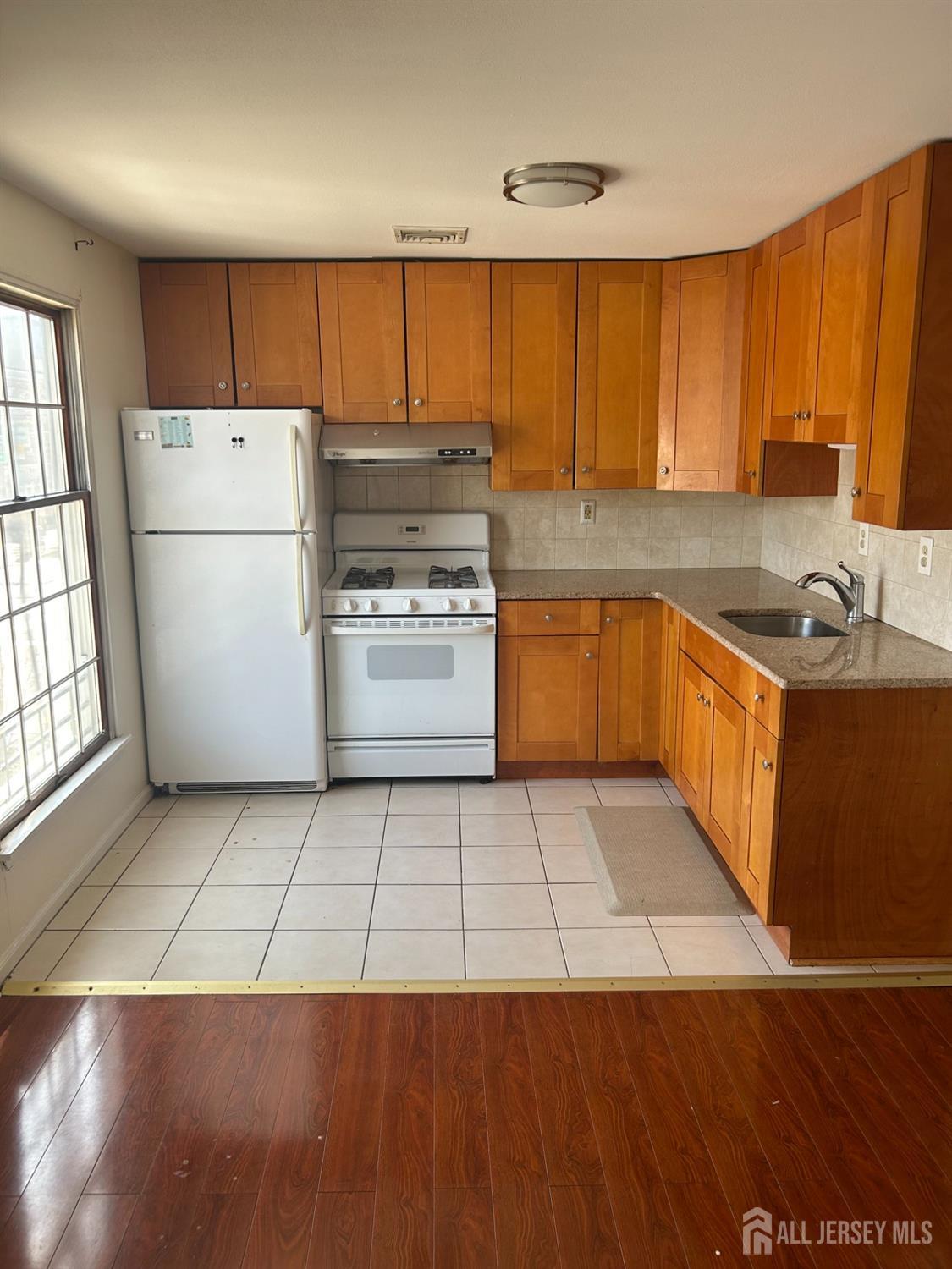435 Main Street, Unit 2D Metuchen, NJ 08840 - Photo 2 of 8 a kitchen with a sink a refrigerator and a stove top oven