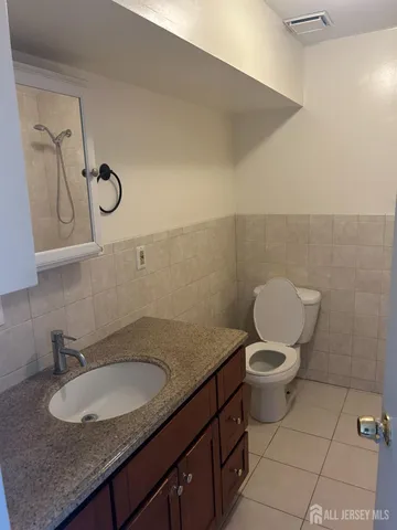 a bathroom with a granite countertop sink mirror vanity and toilet
