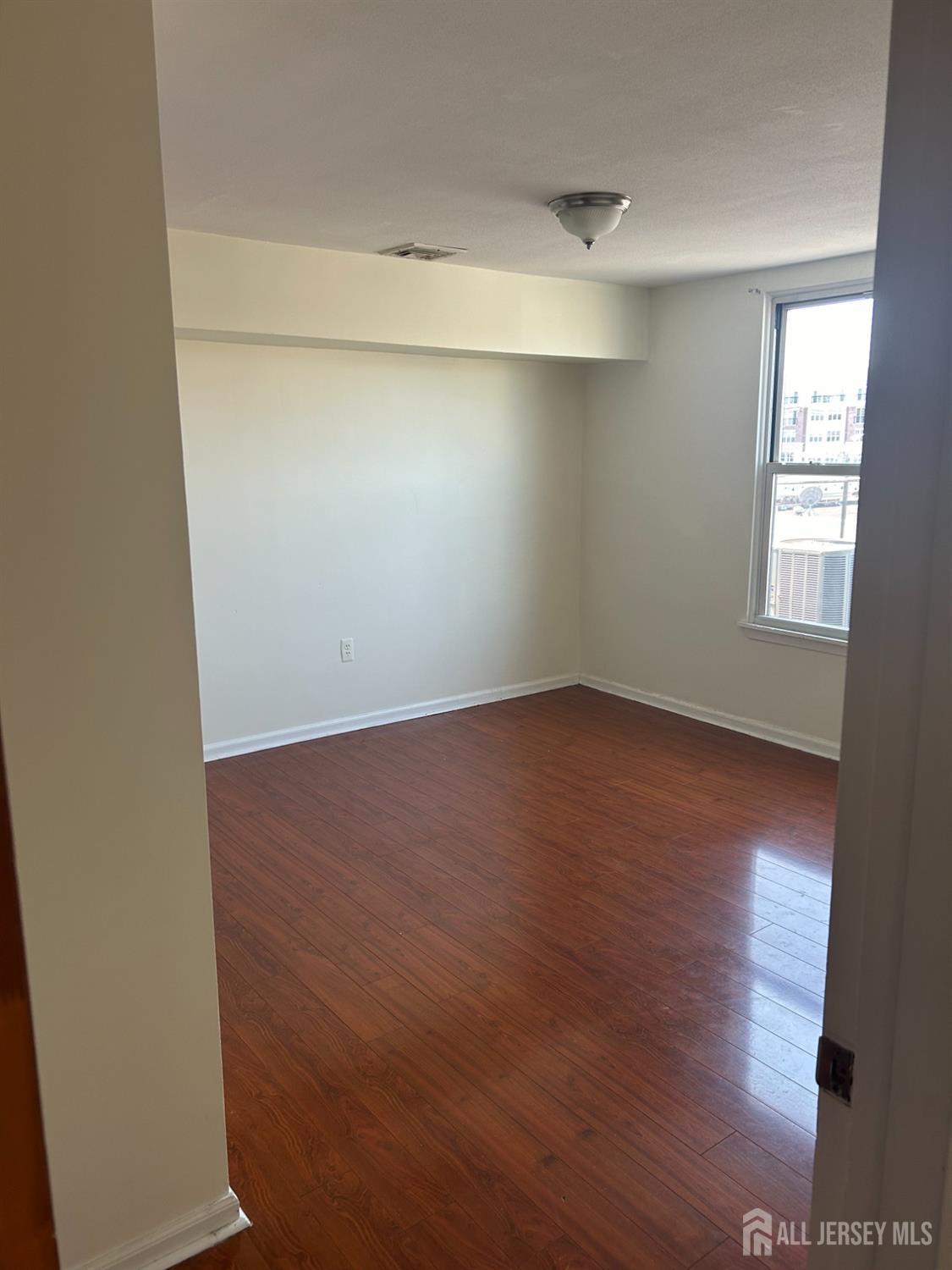 435 Main Street, Unit 2D Metuchen, NJ 08840 - Photo 7 of 8 an empty room with wooden floor and windows