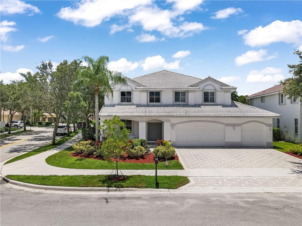 934 Crestview Circle Fort Lauderdale, FL 33327 - Photo 3 of 51 a front view of a house with a garden and plants
