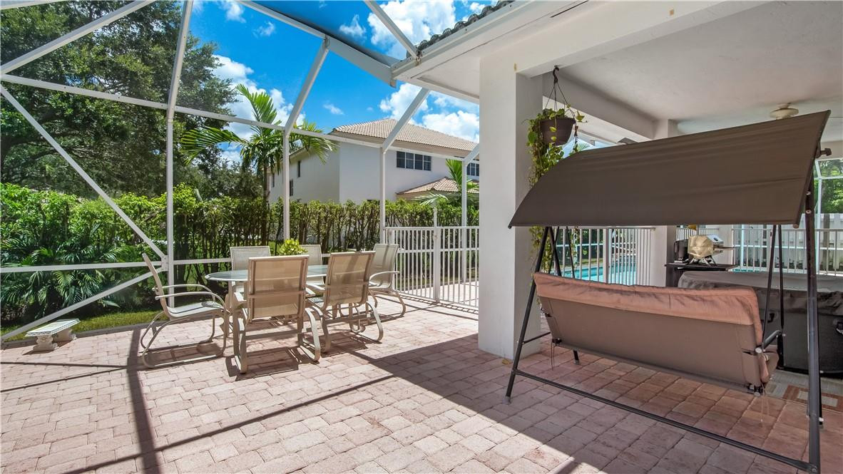 934 Crestview Circle Fort Lauderdale, FL 33327 - Photo 49 of 51 a view of a patio with a dining table and chairs with wooden floor and fence