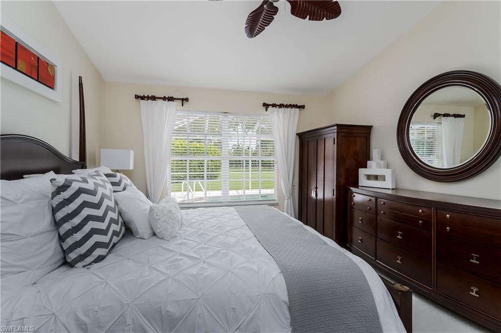 6658 Castlelawn Place, Unit 9 Naples, FL 34113 - Photo 18 of 38 Bedroom featuring light-toned walls, a dark wood-finish four-poster bed frame, and carpeted flooring