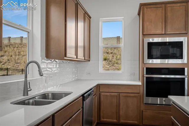 a kitchen with stainless steel appliances a sink stove and microwave