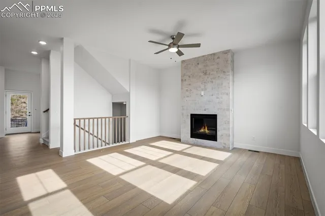 wooden floor fireplace and windows in an empty room