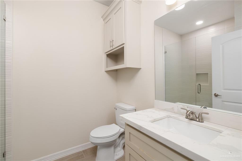 1717 Alisson Street Alton, TX 78573 - Photo 11 of 15 a bathroom with a granite countertop sink toilet and mirror