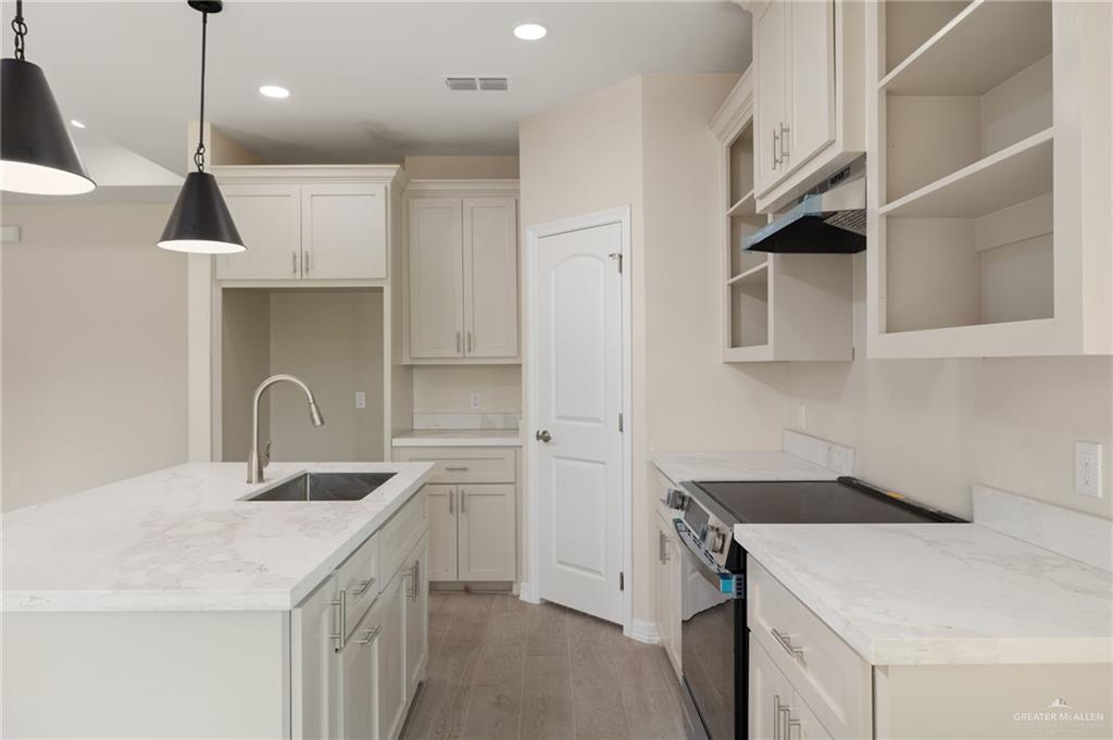 1717 Alisson Street Alton, TX 78573 - Photo 5 of 15 a kitchen with a sink a stove and cabinets
