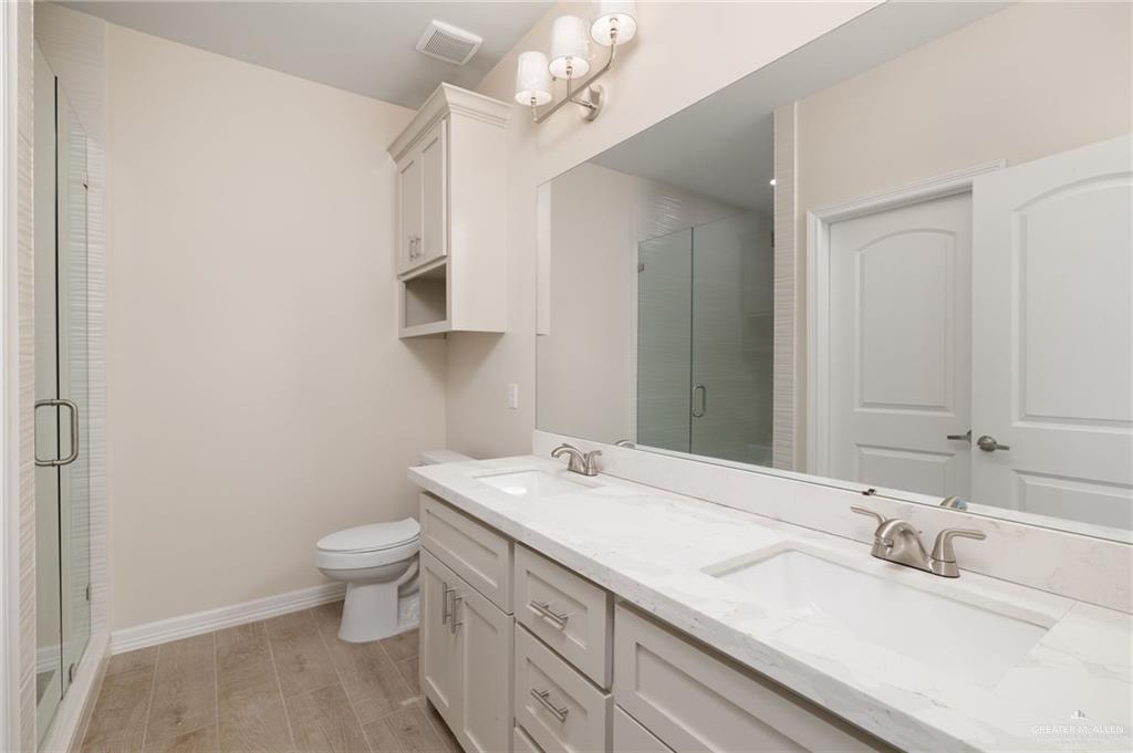 1717 Alisson Street Alton, TX 78573 - Photo 8 of 15 a bathroom with a granite countertop sink a toilet and a mirror