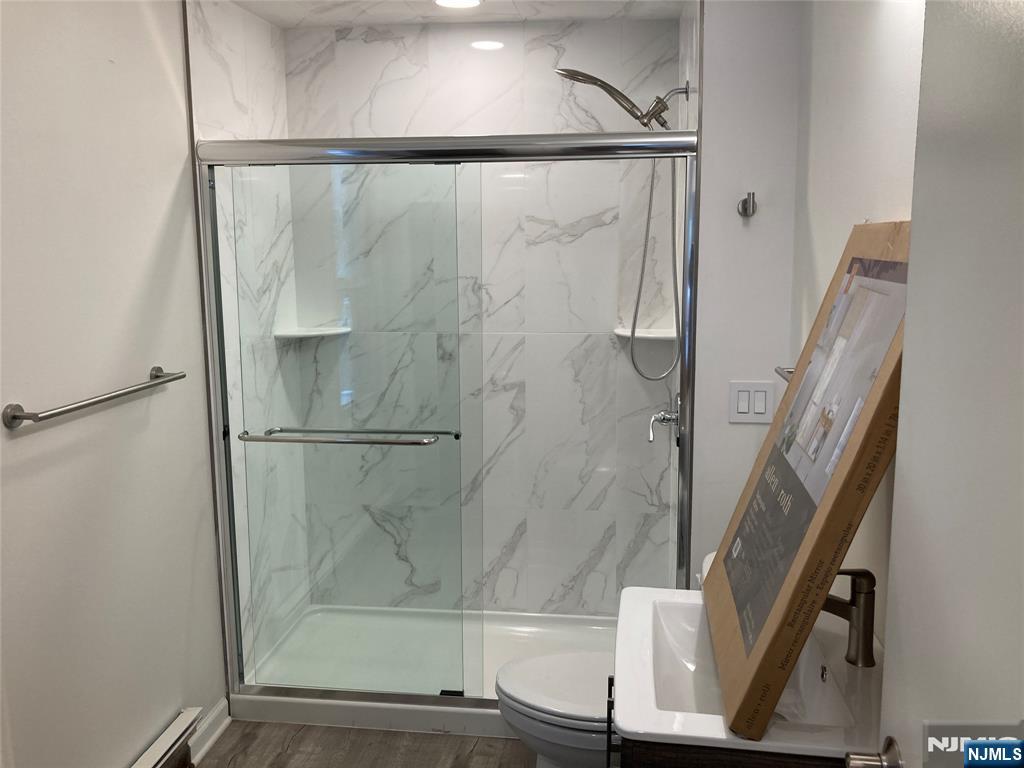 118 Doremus Avenue, Unit C Ridgewood, NJ 07450 - Photo 16 of 16 a bathroom with a glass shower door