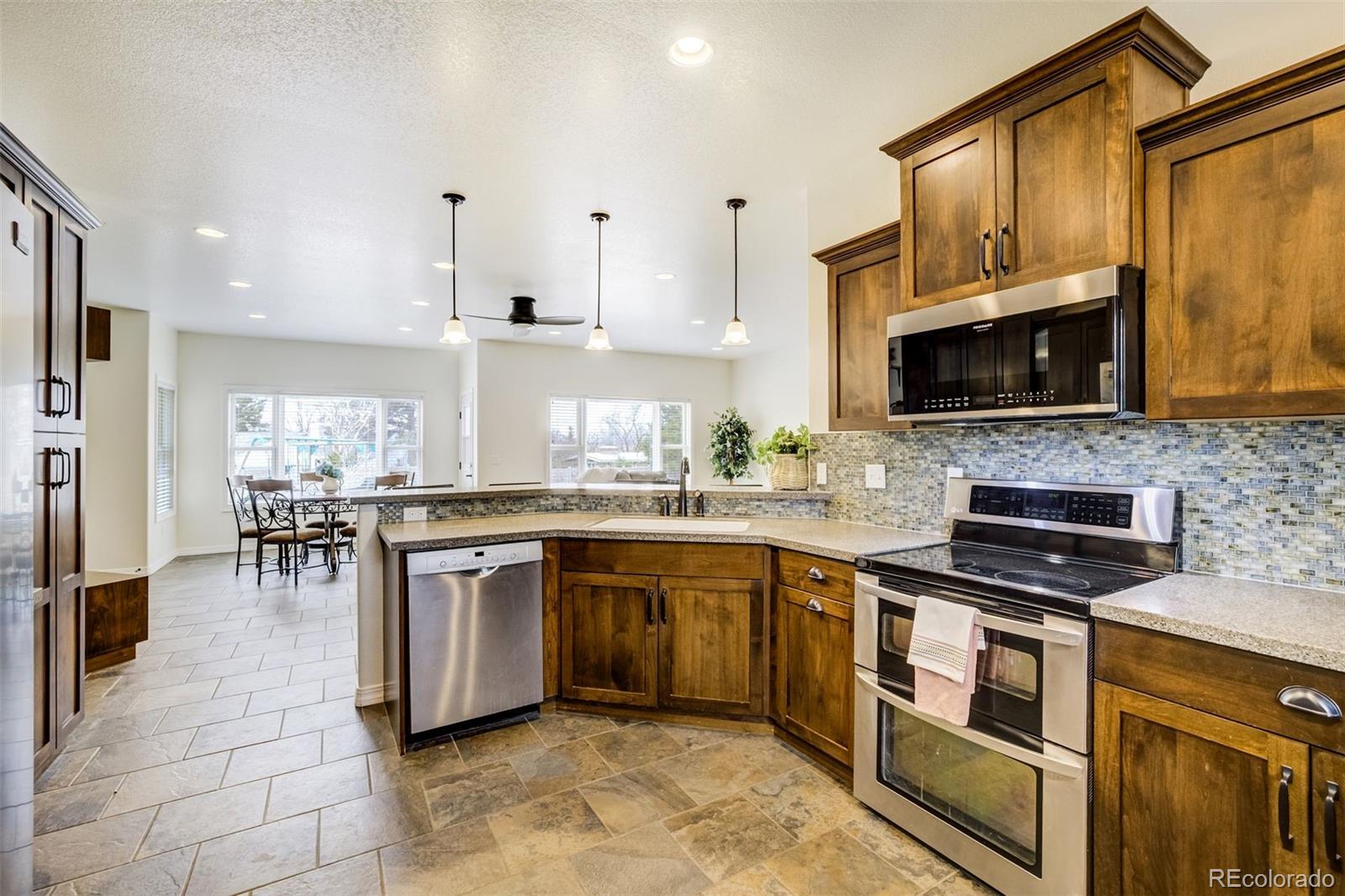 675 9th Street Limon, CO 80828 - Photo 24 of 49 a kitchen with stainless steel appliances granite countertop a stove top oven a sink dishwasher a dining table and chairs