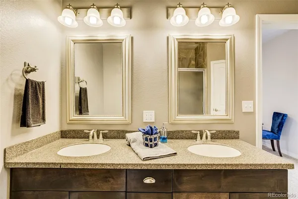 a bathroom with a granite countertop double vanity sinks and a mirror