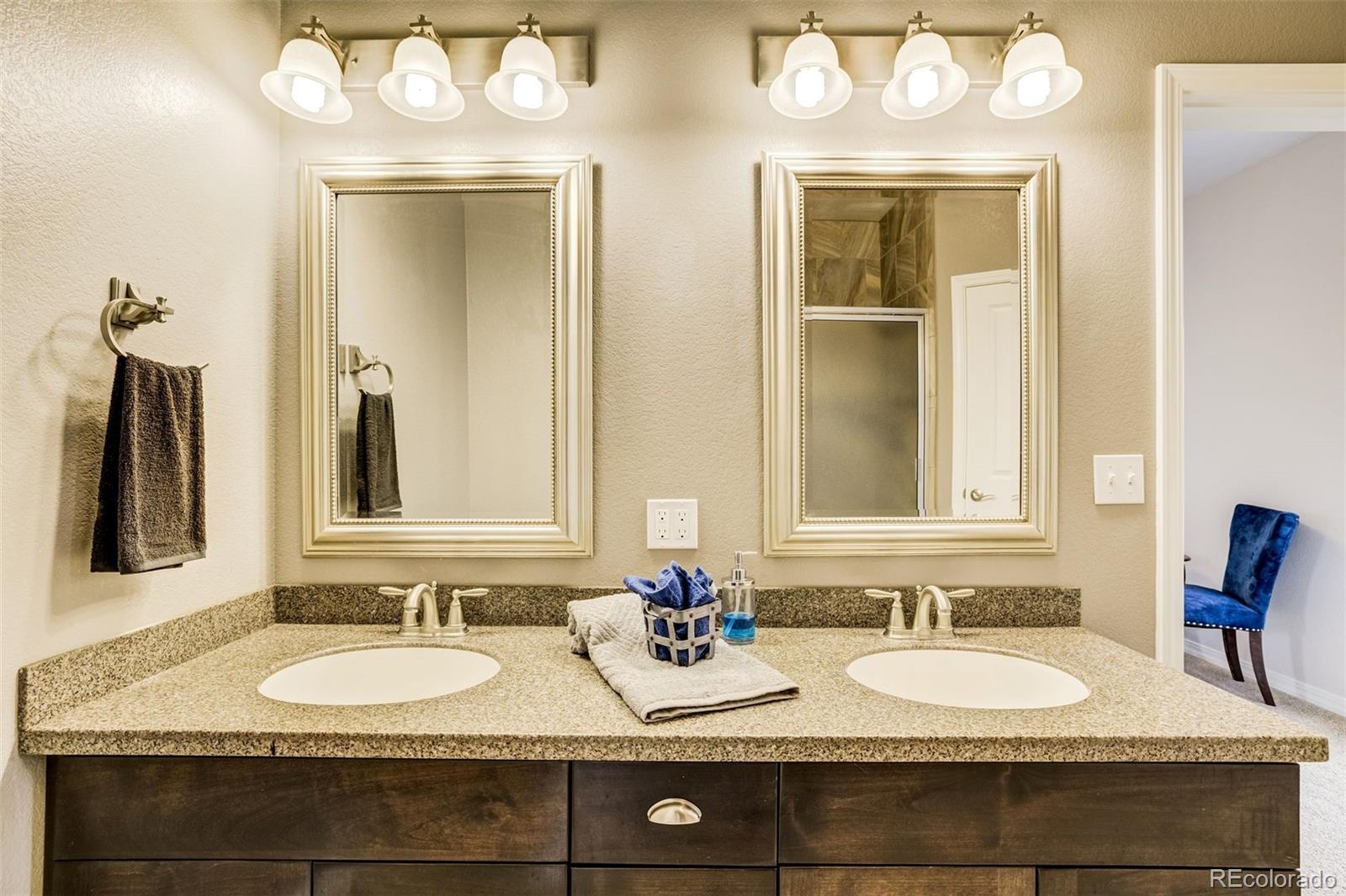 675 9th Street Limon, CO 80828 - Photo 30 of 49 a bathroom with a granite countertop double vanity sinks and a mirror