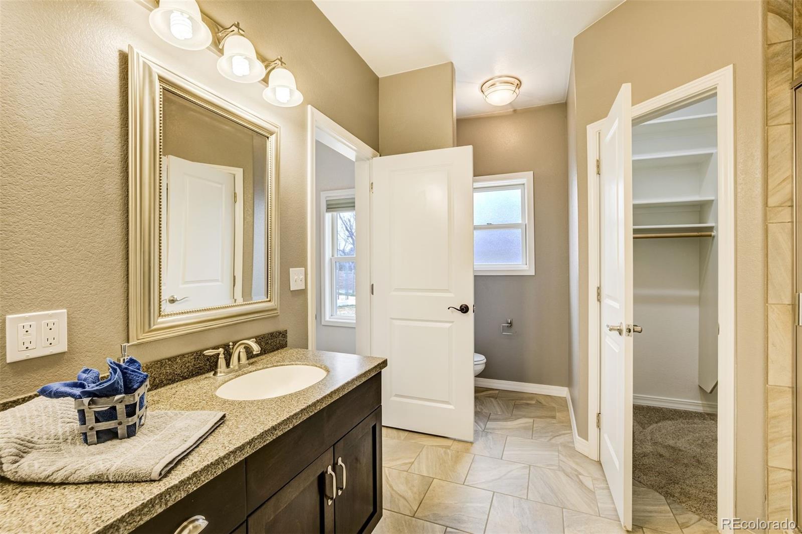 675 9th Street Limon, CO 80828 - Photo 31 of 49 a bathroom with a granite countertop sink and a mirror