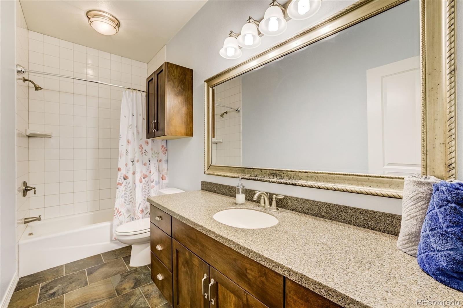675 9th Street Limon, CO 80828 - Photo 9 of 49 a bathroom with a granite countertop sink a toilet a mirror a vanity and bathtub