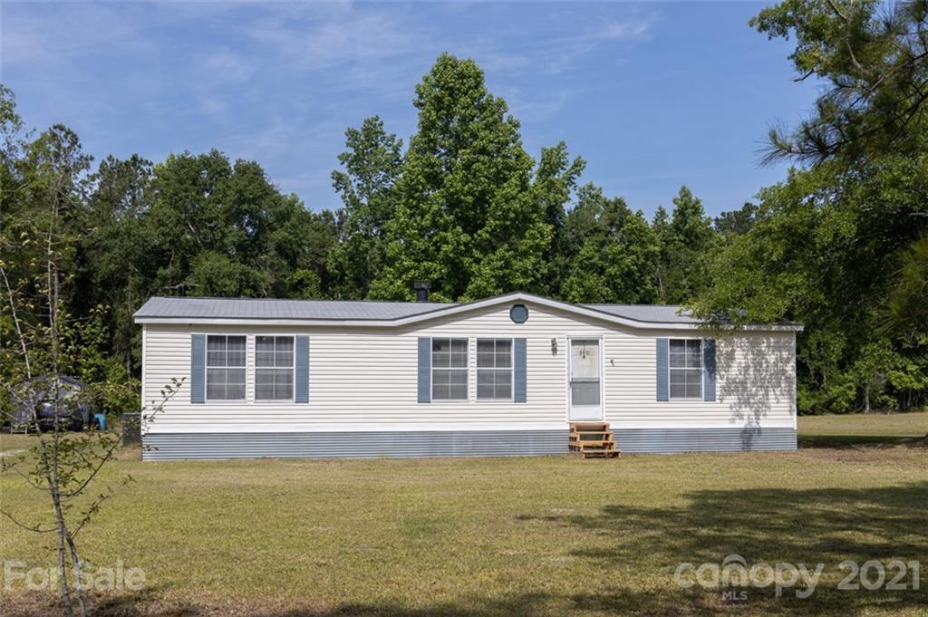 340 Old Bridge Road Rocky Point, NC 28457 - Photo 1 of 35 a front view of a house with a garden