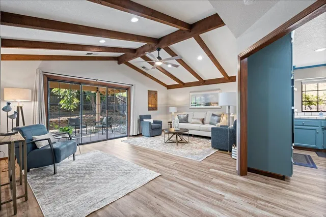 a living room with furniture large window and wooden floor