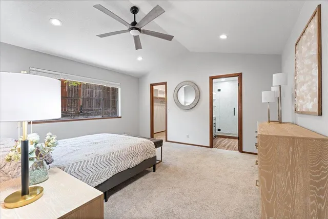 a spacious bedroom with a bed couch and window