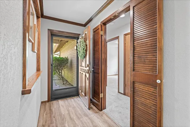 a view of a hallway with wooden floor and a door