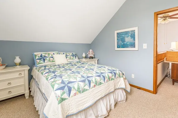 a bedroom with a bed and a lamp on dresser