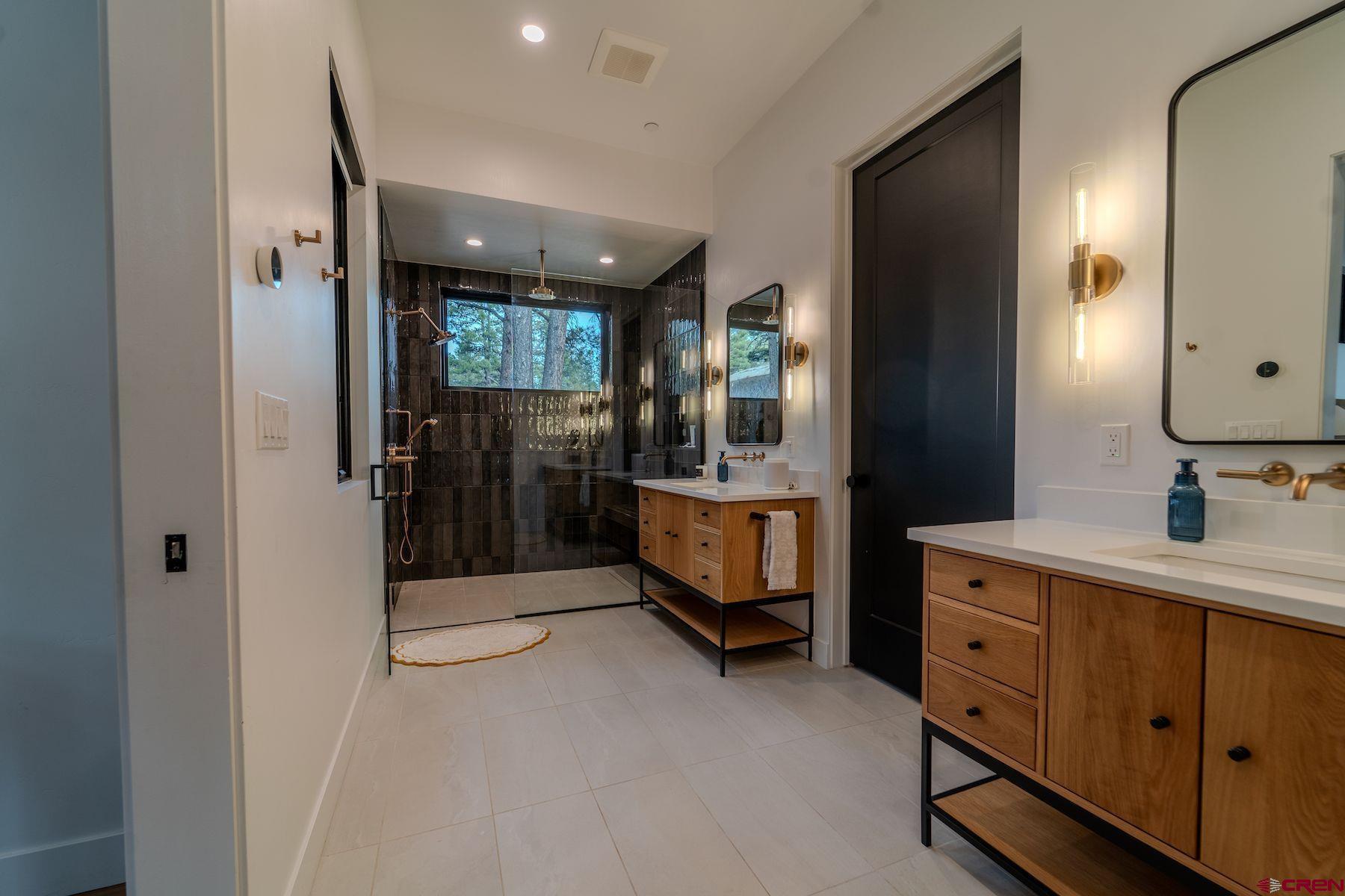 46 Bell Flower Court Durango, CO 81301 - Photo 21 of 40 a spacious bathroom with a double vanity sink a mirror and shower
