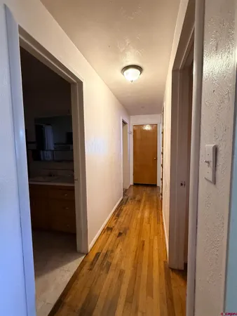 a view of a hallway with wooden floor and staircase