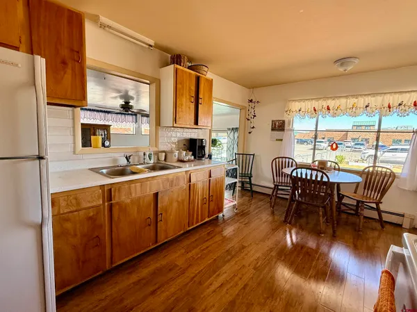 a kitchen with stainless steel appliances granite countertop a table chairs and a refrigerator